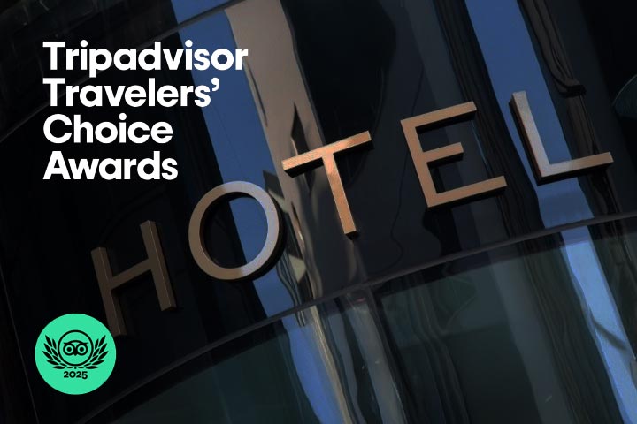 Gebäudefassade eines Hotels mit reflektierendem Glas und dem Logo der Tripadvisor Travellers’ Choice Awards 2025