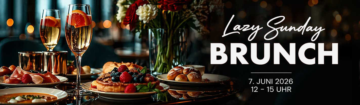 Sektgläser, Brunchgerichte und Blumen auf gedecktem Tisch im Hotel in Regensburg