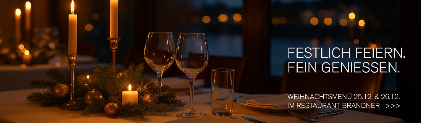 Festlich gedeckter Tisch mit Kerzen und Donau-Blick zum Weihnachtsmenü im Restaurant Brandner Regensburg