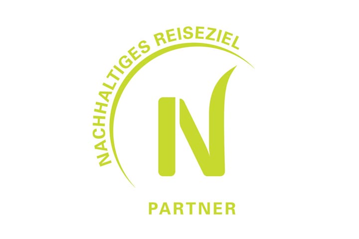 Grünes Logo der TourCert Zertifizierung ‚Nachhaltiges Reiseziel Partner‘ für das SORAT Insel-Hotel Regensburg
